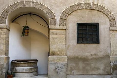 Rustic Stone Courtyard with Arched Entry and Old Well 스톡 사진