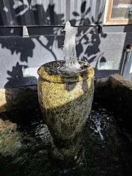 Rustic Stone Fountain with Vertical Stream Stock Photos