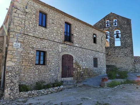Rustic stone house and old church bell tower in Castellet village, Spain. Stock Photos