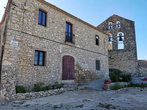 Rustic stone house and old church bell tower in Castellet village, Spain. Stock Photos