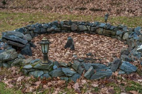 A rustic stone outdoor design surrounded by dry autumn leaves and vintage Stock Photos
