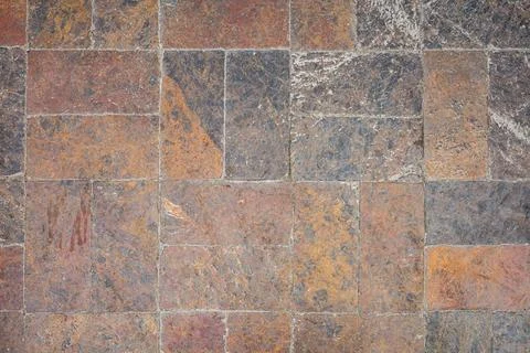 Rustic stone tile surface with natural texture and earth tones 스톡 사진
