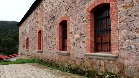 Rustic stone wall and windows with bricks and English-style iron bars Stock Footage 287496193