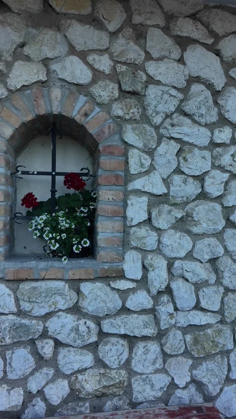 Rustic stone wall with arched windows and blooming flowers Stock Footage 341526059