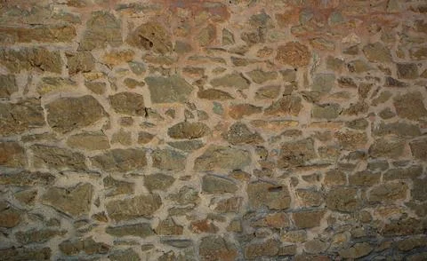 Rustic stone wall built with irregular clay bricks and mortar in a Mediterr.. Stock Photos