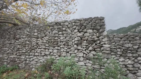 Rustic stone wall built without cement in remote woodland Stock Footage 338109296