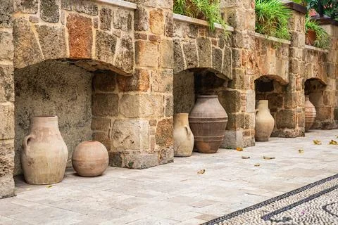 Rustic stone wall with clay pots in a mediterranean courtyard Stock Photos
