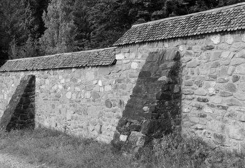 A rustic stone wall featuring prominent buttresses for structural support Stock Photos