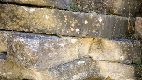Rustic stone wall texture with layered rocks Stock Photos