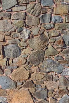 Rustic stone wall texture showcases a blend of colors and shapes in a charm.. Foto stock