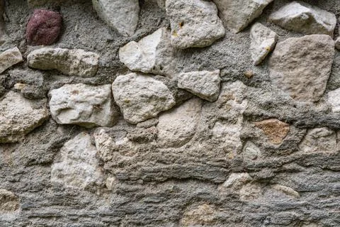 Rustic stone wall with various rock shapes and textures Stock Photos