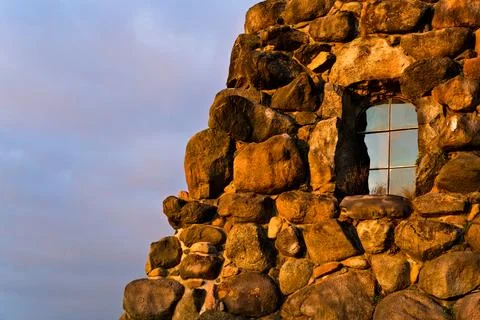 Rustic Stone Wall with Window at Sunset Stock Photos