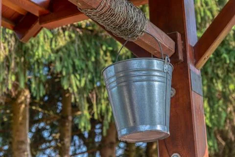 Rustic stone well with bucket and drinking water. Photos