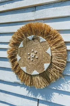 Rustic straw circle mounted on blue wall. Vivid straw decoration featured a.. Stock Photos