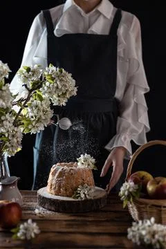 Rustic style apple bundt cake with powdered sugar. Woman sprinkles icing suga Stock Photos