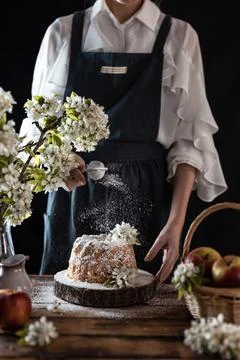 Rustic style apple bundt cake with powdered sugar. Woman sprinkles icing suga Stock Photos