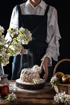 Rustic style apple bundt cake with powdered sugar. Woman sprinkles icing suga Stock Photos
