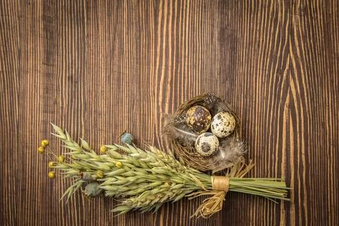 Rustic style Easter decoration - nest with eggs and bouquet of dry herbs on v Stock Photos