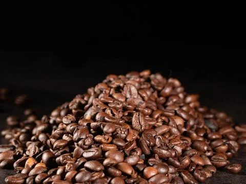 Rustic style roasted coffee beans on dark background - low key photography Stock Photos