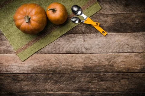 Rustic style two pumpkins with spoons on green napkin and wood Stock Photos