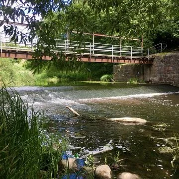 Rustic Summer Charm Iron Bridge Over River and Waterfall Stock Photos