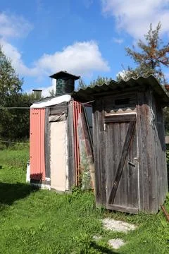 A rustic summer shower with a barrel for heating water on the roof and a toil Stock Photos