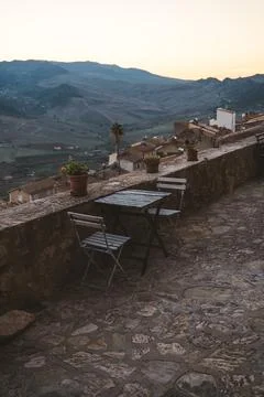Rustic table and chairs with mountain view at sunset in a Sicilian village Stock Photos