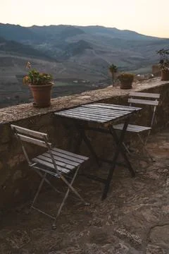 Rustic table and chairs with mountain view at sunset in a Sicilian village Stock Photos