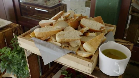 A rustic table made from a wooden crate, on which there are slices of bread Stock Footage 254097300