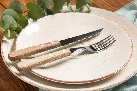 Rustic table setting with knife and fork on ceramic plates Stock Photos