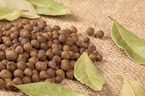 Rustic table setting with a mixture of black pepper and bay leaf spices Stock Photos
