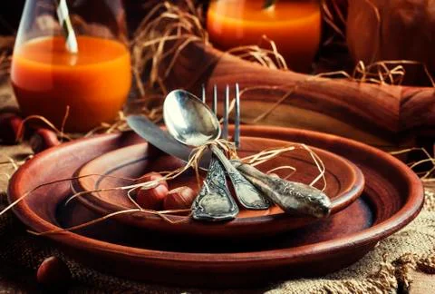 Rustic table setting for Thanksgiving Day: pottery, vintage appliances, straw Stock Photos