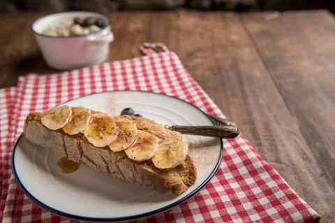 Rustic table with sourdough bread slice with peanut butter and banana Stock Photos