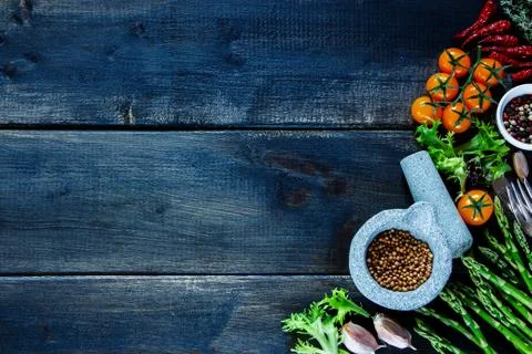 Rustic table with various colorful spices and vegetables Stock Photos