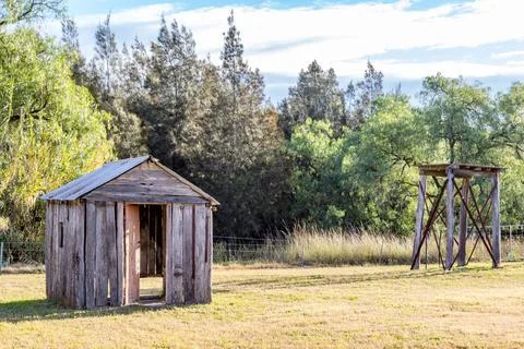 A rustic timber cabin stands weathered and worn in a quiet rural landscape Stock Photos