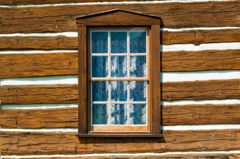 Rustic timber wall  with a window covered inside by a lace curtain Stock Photos