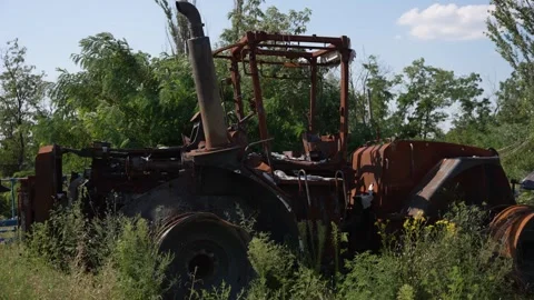 Rustic Tractor in Disrepair. Rusted tractor overtaken by vegetation, relic of Stock Footage 270094370