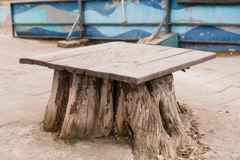 Rustic Tree Stump Table With Weathered Wood Planks On Concrete Patio Near B.. Фото