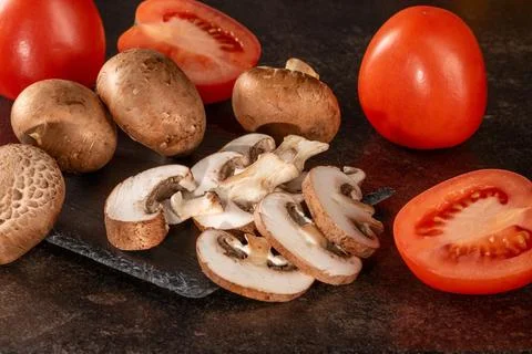 Rustic vegetable mix of fresh tomatoes and mushrooms on dark wooden table Stock Photos