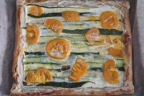 A rustic vegetable tart featuring zucchini and heirloom tomato slices atop a  Stock Photos