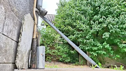 Rustic Village Yard with an Old House and Weathered Drainpipe Vídeos de archivo 344055643