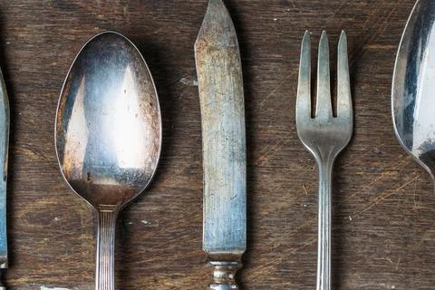 Rustic vintage silverware set on aged wooden table Stock Photos