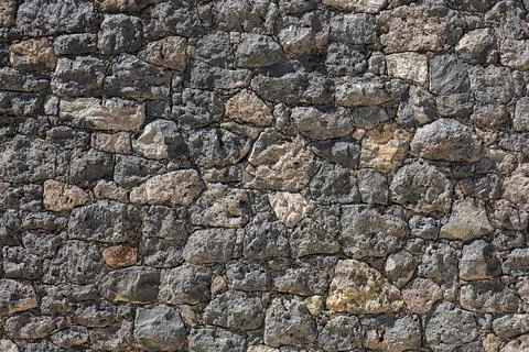 Rustic volcanic stone wall background with textured dark grey and brown ign.. 스톡 사진
