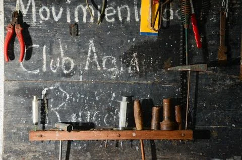 Rustic wall with vintage tools and wooden shelf, evoking nostalgia and craft. Stock Photos