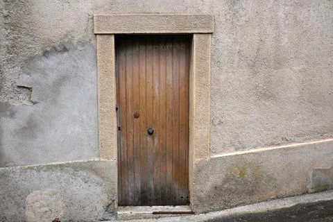 Rustic weathered wooden door in a textured stone wall of an old European bu.. Stock Photos