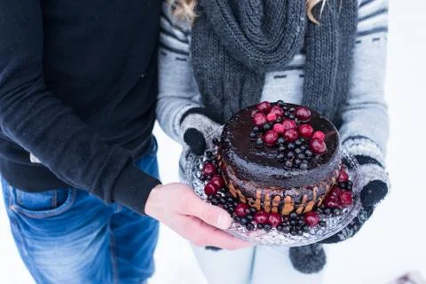 Rustic wedding cake with berries in hand of couple Stock Photos