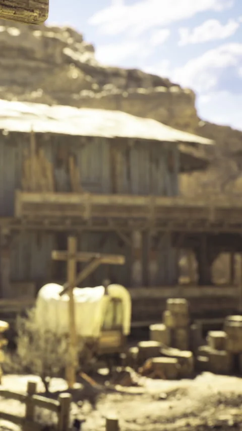 Rustic western town scene with an old barn and wooden signpost under bright sky Stock Footage 331833679