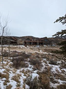 Rustic Whiskey Distillery Surrounded by Snowy Hills and a Winter Landscape. Stock-Fotos