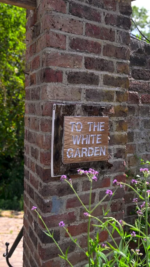 Rustic To The White Garden Sign On Brick Pillar With Summer Flowers Stock Footage 340318924