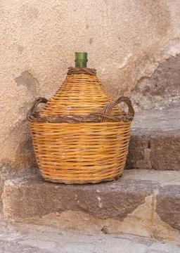 Rustic Wicker Demijohn on Stone Steps Fotos de archivo